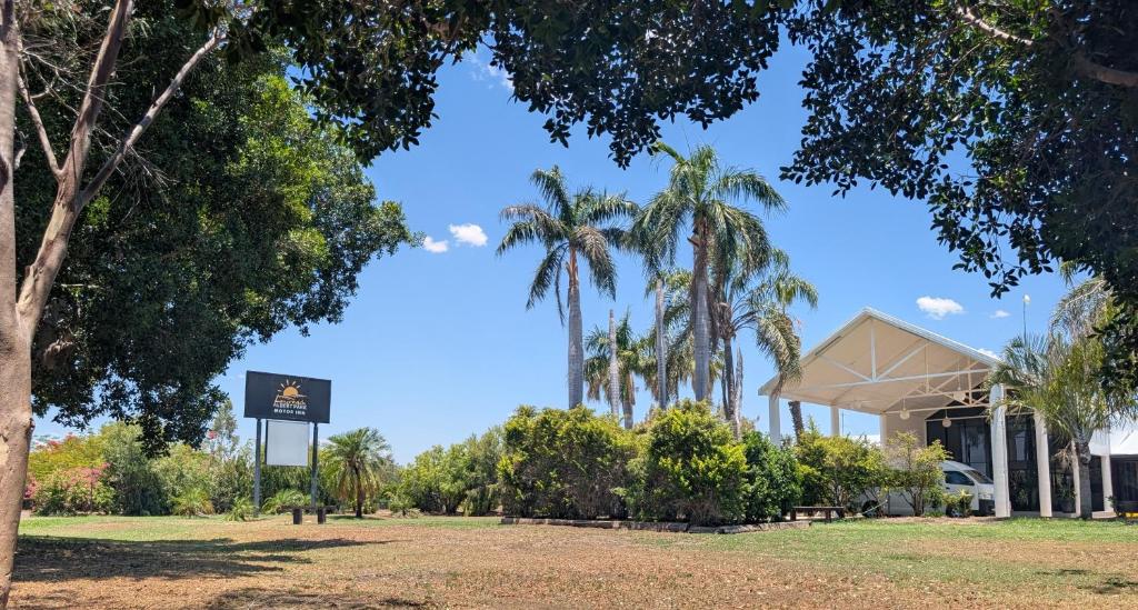 un edificio con palmeras delante en Albert Park Motor Inn, en Longreach