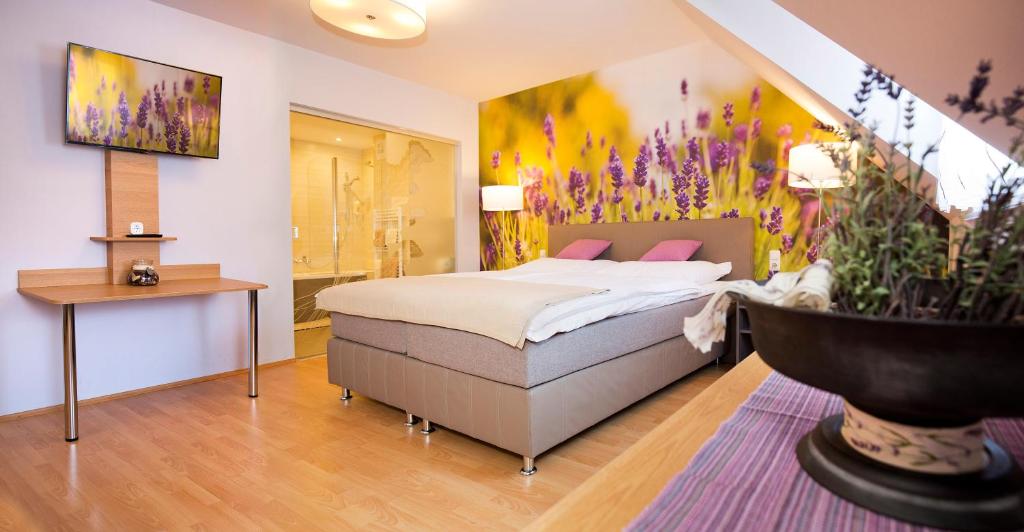 ein Schlafzimmer mit einem großen Bett und einer Badewanne in der Unterkunft Hotel & Wirtshaus Hödl-Kaplan in Feldbach
