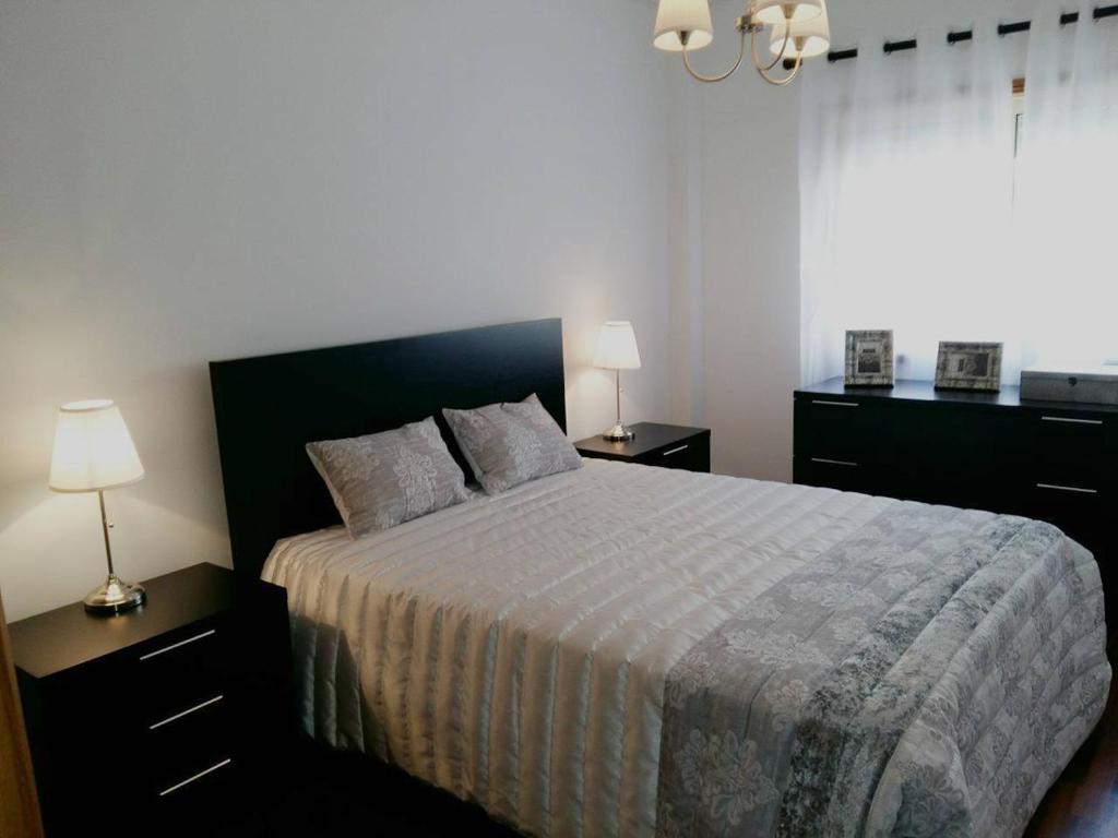 アヴェイロにあるLovely Apartment Aveiroのベッドルーム1室(ランプ2つ、窓付)