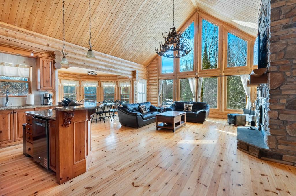 a kitchen and living room with wooden floors and windows at Fiddler Lake Resort - Deer 9 in Mille-Isles