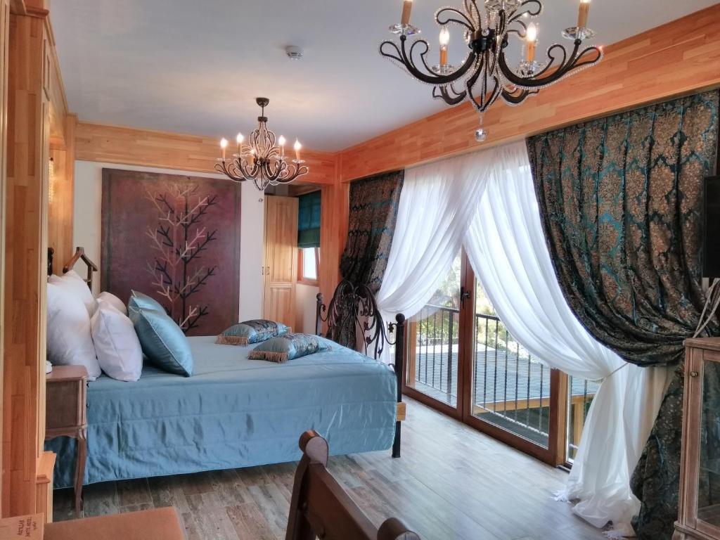 a bedroom with a bed and a chandelier at Aşıklar Otel By Şükrü in Buyukada