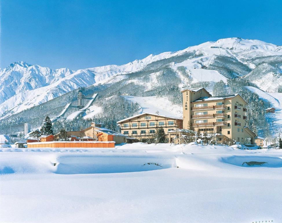 a resort in the snow with a mountain at Hotel Goryukan in Hakuba