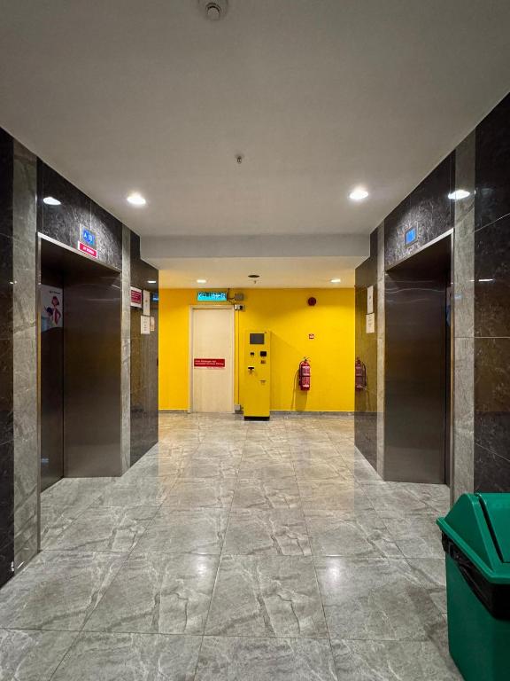 a hallway with yellow walls and doors in a building at NEW Bangsar Trade Centre KL Mid Valley LRT Bangsar in Kuala Lumpur