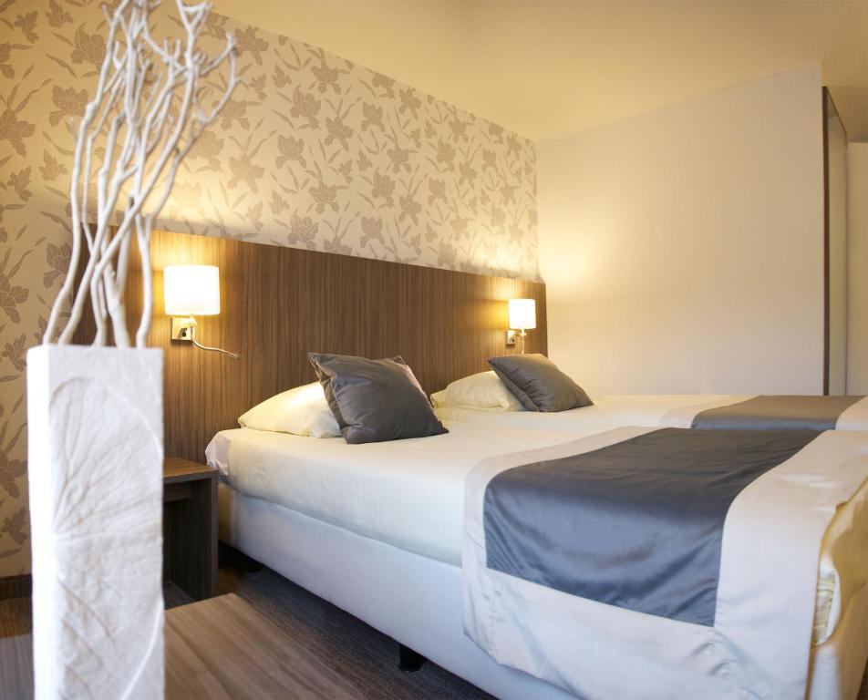 een hotelkamer met 2 bedden in een kamer bij Hotel Asteria in Venray