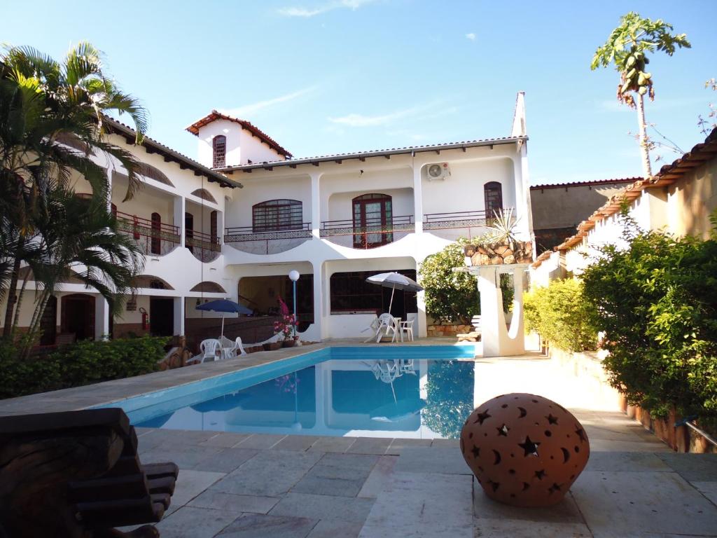 una casa con piscina delante en Pousada Pollyana, en Pirenópolis