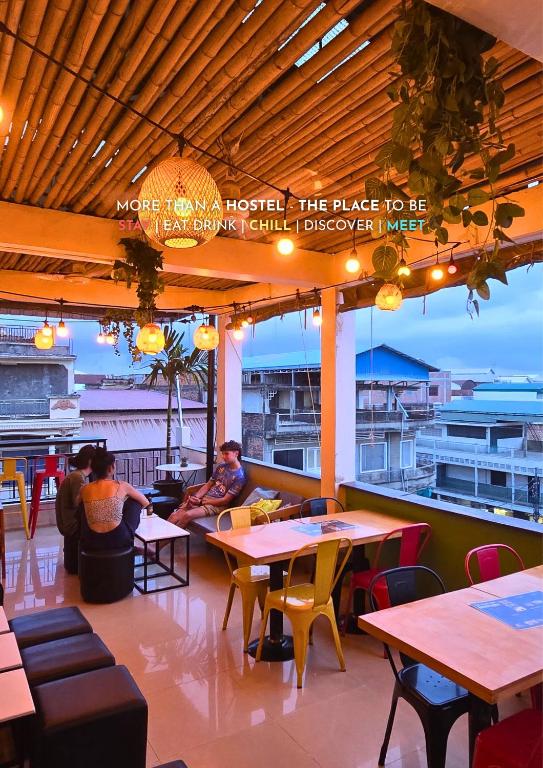 马德望THE PLACE Hostel Battambang的一间设有桌椅的餐厅,有座位
