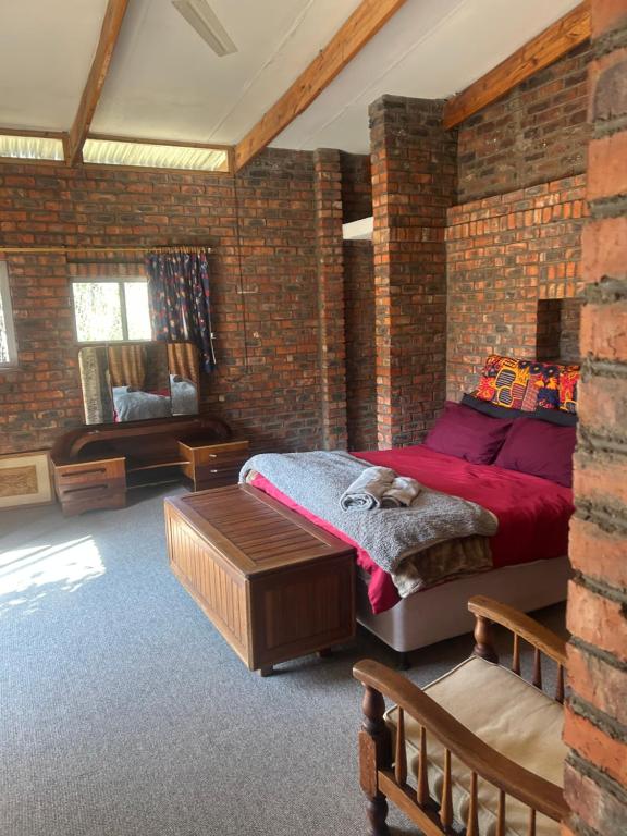 a brick walled bedroom with a bed with a cat on it at Biba's Rooms in Smithfield