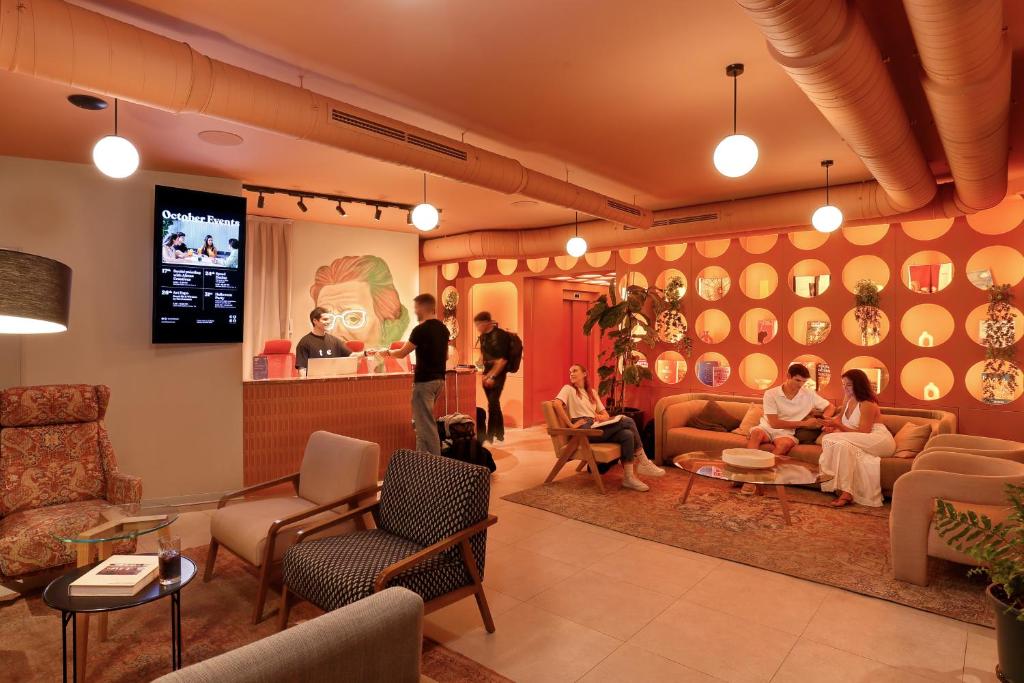 a group of people sitting in a waiting room at Coeo Hernan Ruiz Rooftop Pool Hostel in Málaga