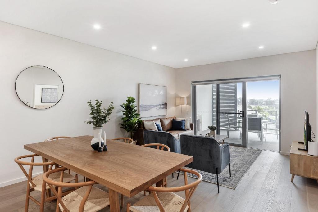 un salon avec une table, des chaises et un canapé dans l'établissement 3-Bed Apartment in Beautiful Kiama with Study Nook, à Kiama