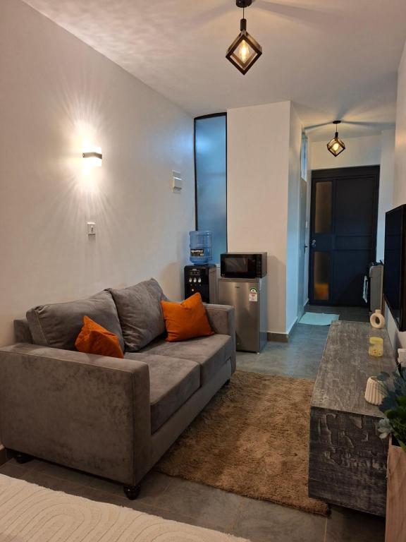 a living room with a couch and a kitchen at The Nest cozy stays in Kiambu