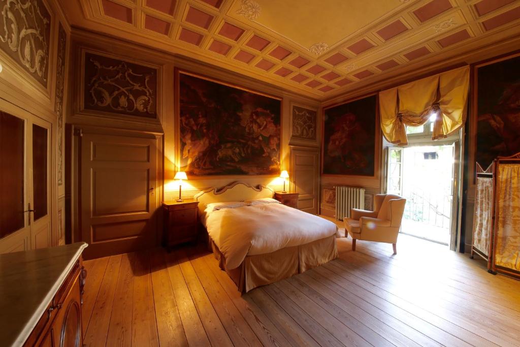 San BernardoにあるPalazzo Guicciardiのウッドフロアのベッドルーム1室(ベッド1台付)