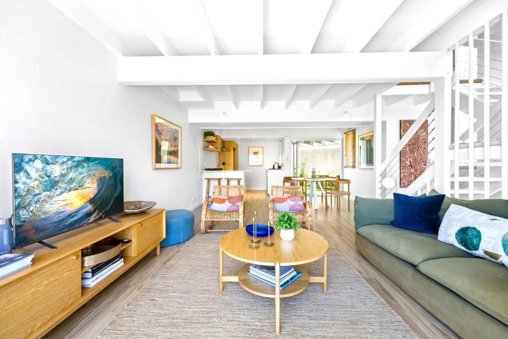 un salon avec un canapé et une table dans l'établissement 2-Bed Coastal Haven with Pool by Sunshine Beach, à Sunshine Beach