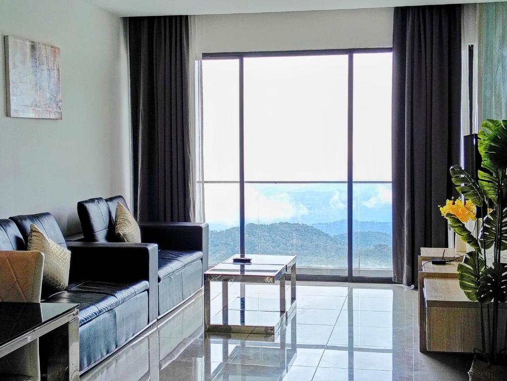 a living room with a couch and a large window at Genting Peak by Emerald Homes at Grand Ion Delemen Genting Highlands in Genting Highlands