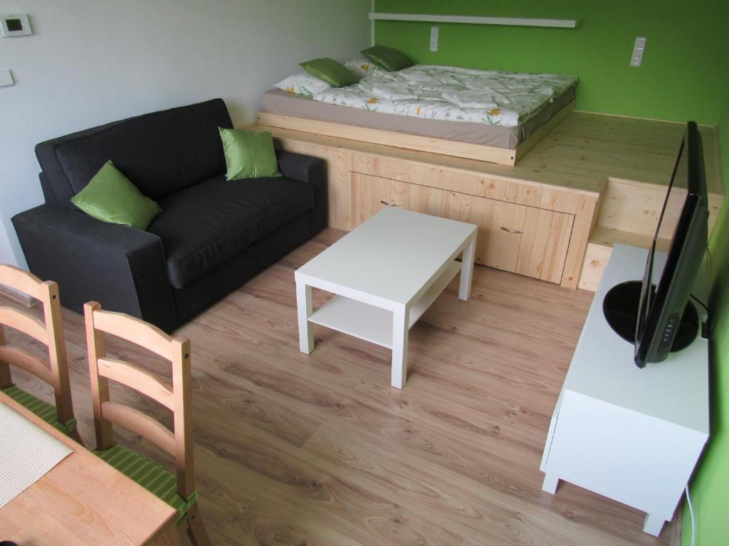 a small living room with a bed and a couch at Apartmán Stožec Ema in Stožec