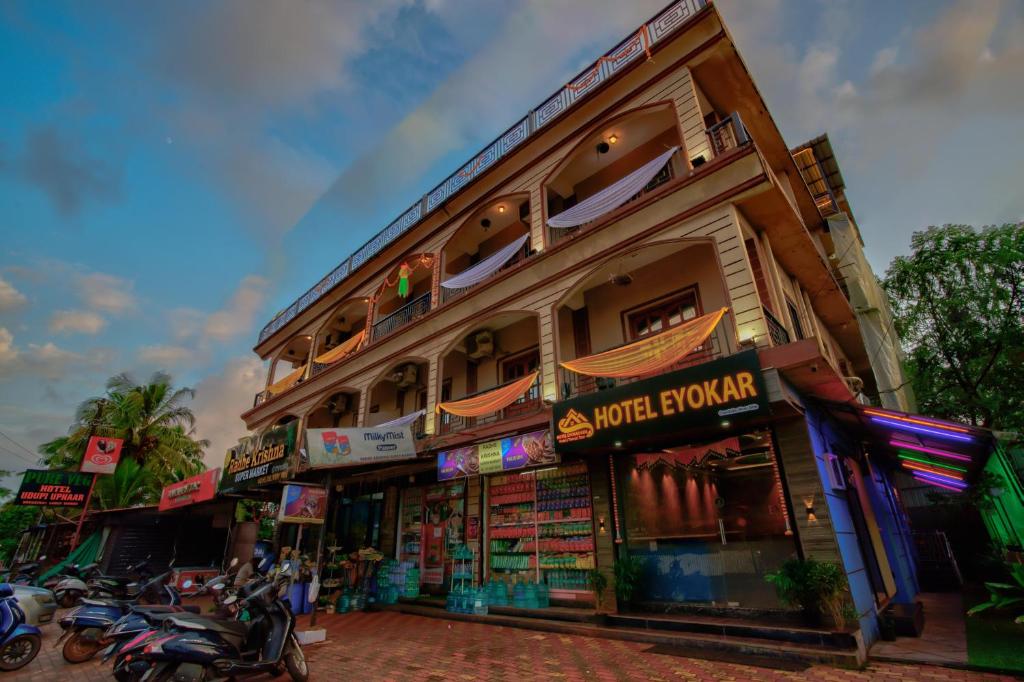 a building with motorcycles parked in front of it at Hotel Eyokar Goa in Candolim