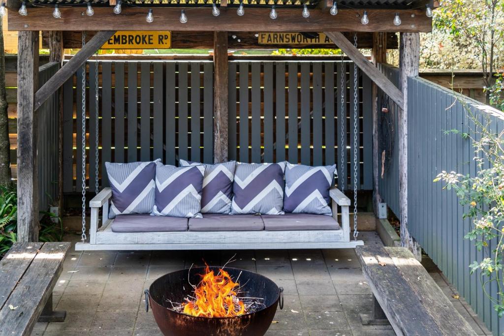 un canapé assis sur un porche à côté d'un foyer dans l'établissement Secluded 3-Bed Retreat Moments to the Beach, à Surf Beach