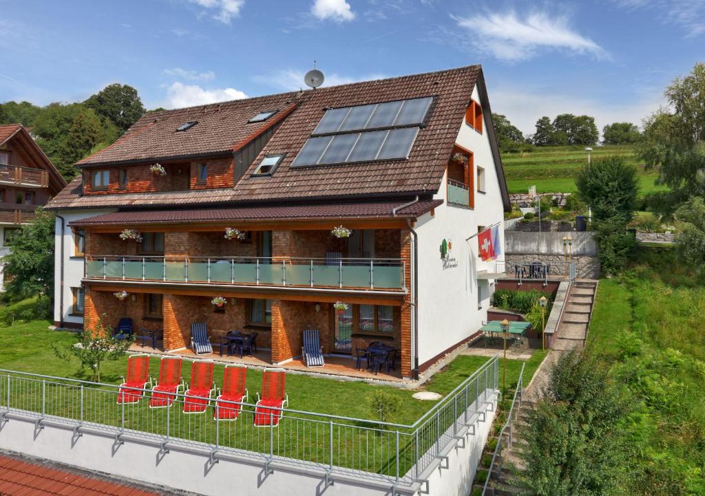 - une vue aérienne sur une maison avec des chaises rouges dans l'établissement Pension Waldwinkel, à Lenzkirch