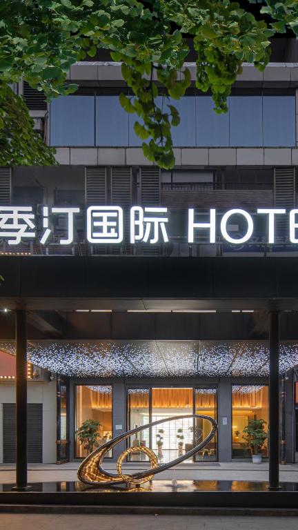 a building with a hotel sign on top of it at Jiting International Hotel Jiaotong University Light Rail Station in Chongqing