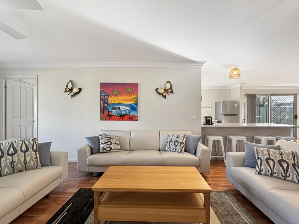 Una sala de estar con dos sofás y una mesa. en Spacious 4-Bed Home 2-Min to the Beach, en Broulee