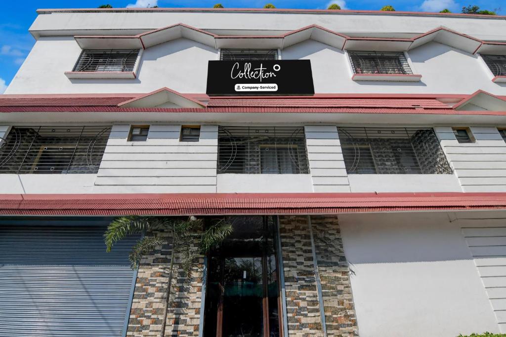 a white building with a black sign on it at Collection O Asian Highway Near Agrasen Hospital Siliguri Formerly Ashiyana Homestay in Binnāguri