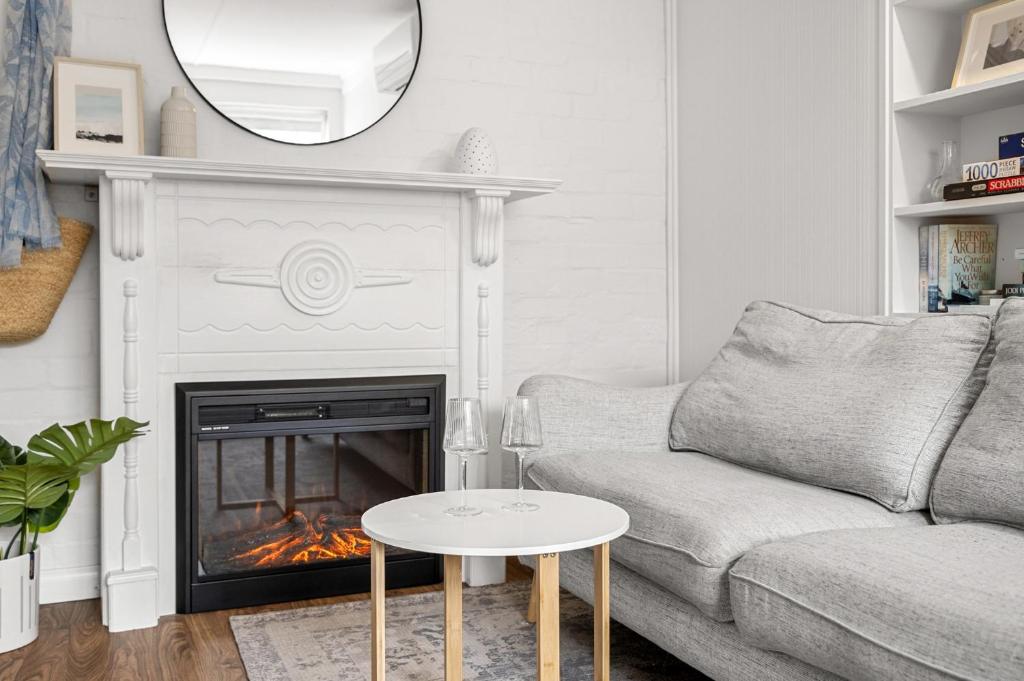 un salon avec un canapé et une cheminée dans l'établissement Charming 1-Bed with Fireplace by the Beach, à Melbourne