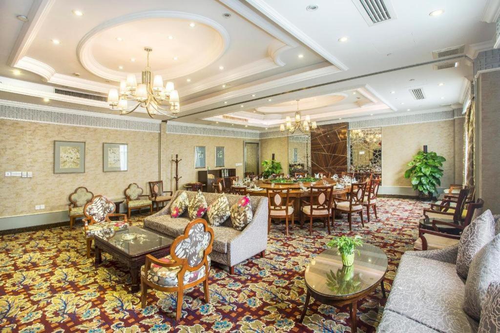uma sala de estar com sofás e uma sala de jantar em Huachen Kenzo Hotel Hangzhou em Hangzhou