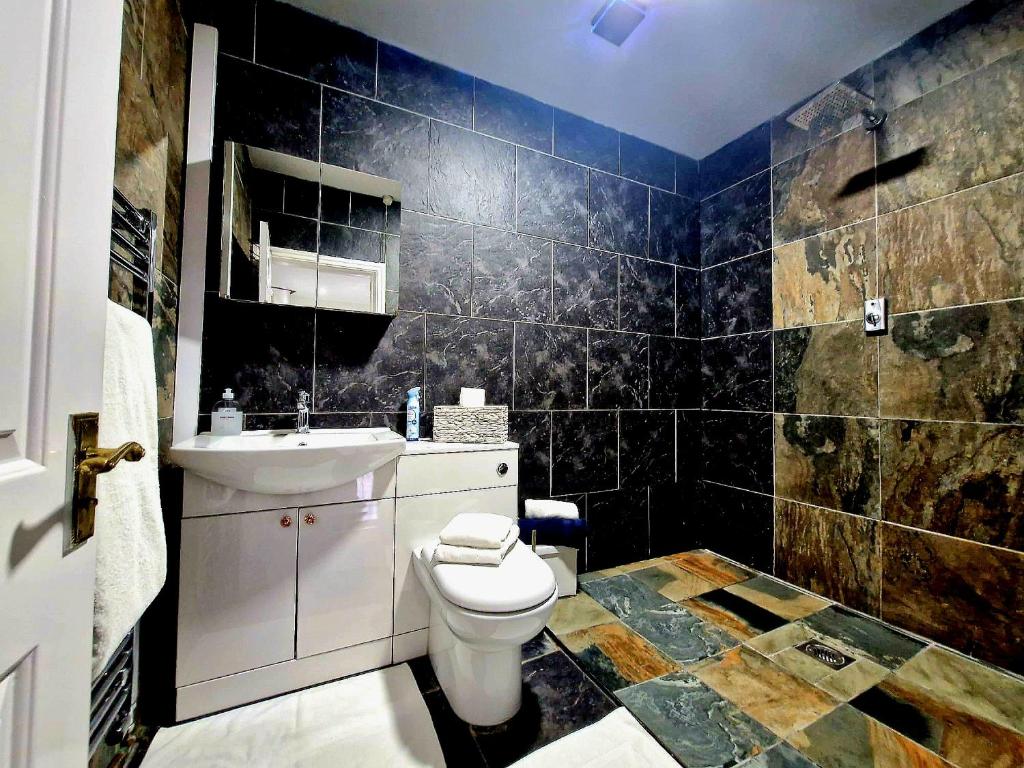 un baño con inodoro y lavabo en Cambridge suites, en Cleethorpes