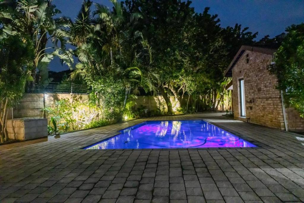 una piscina con luces moradas en un patio en 40 On Jacopever, en Richards Bay