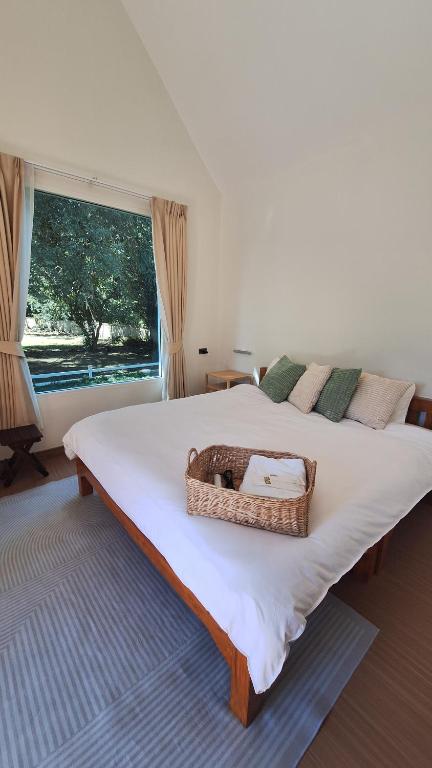 Un dormitorio con una cama grande con una cesta. en Season to table, en Ban Cho Lae