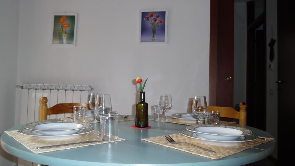 une table avec des assiettes et des verres au-dessus dans l'établissement Appartamento Luminoso, tra mare e lago, à Quiesa