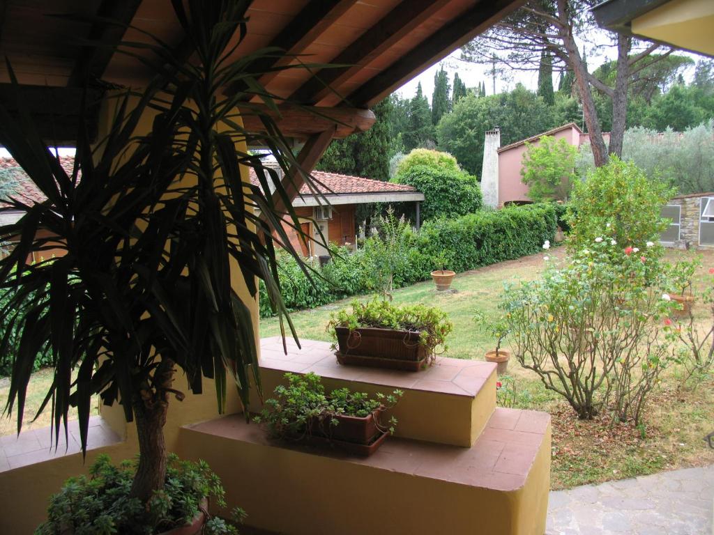 ein Haus mit drei Topfpflanzen auf einer Veranda in der Unterkunft The Colours Of Chianti in Mercatale Val Di Pesa