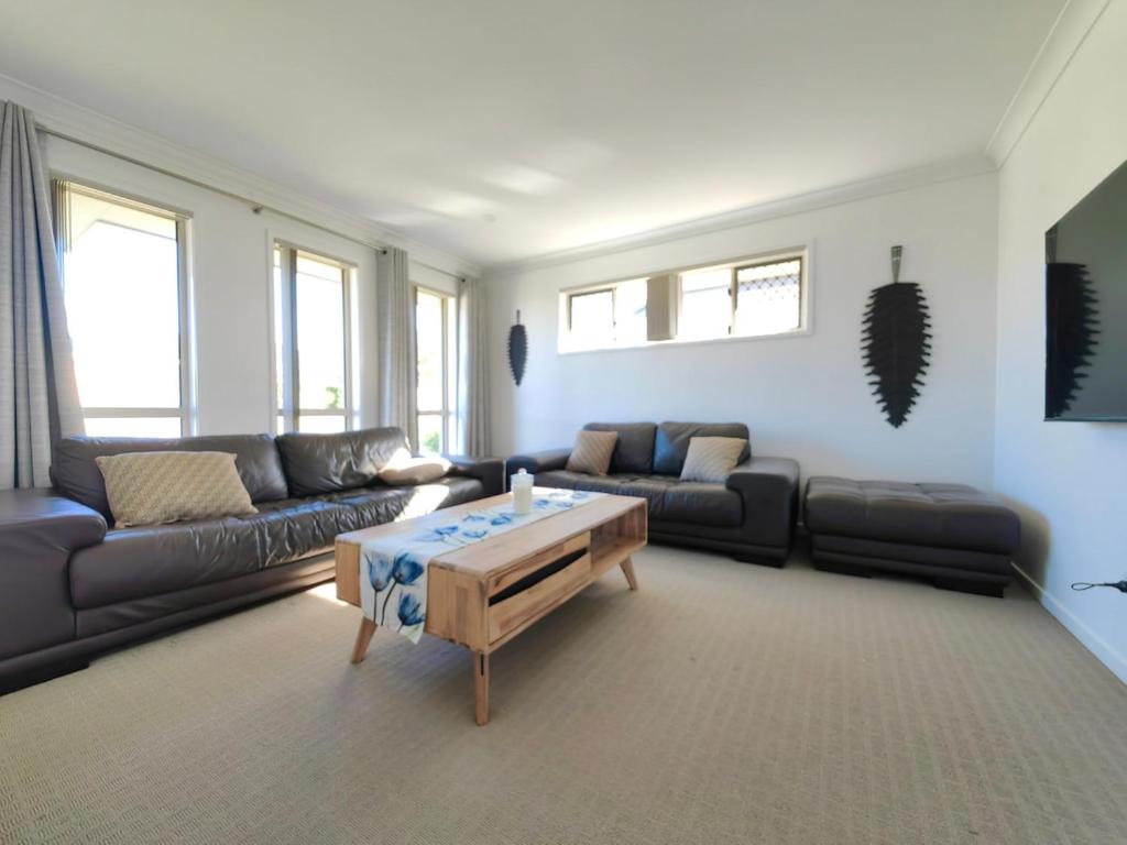 ein Wohnzimmer mit einer Couch und einem Couchtisch in der Unterkunft Stylish Cosy Retreat in North Lakes all Air-Con in North Lakes