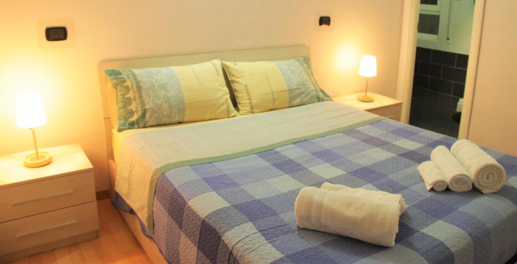 a bedroom with a blue and white bed with towels on it at Hello Roma B&B in Rome