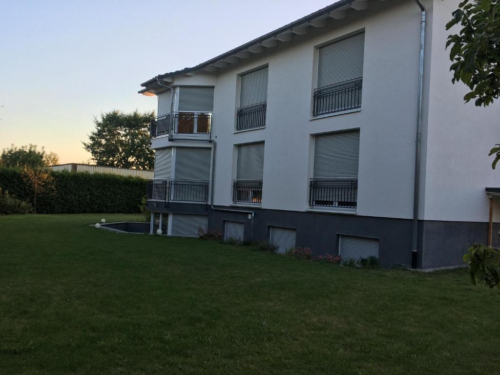 Un edificio de apartamentos con césped delante. en Grefenstein, en Ettenheim