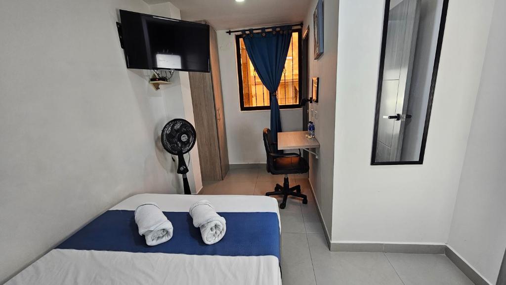 麦德林Hospedaje Andaliving Campo Valdes的一间卧室，床上有一张带毛巾的床