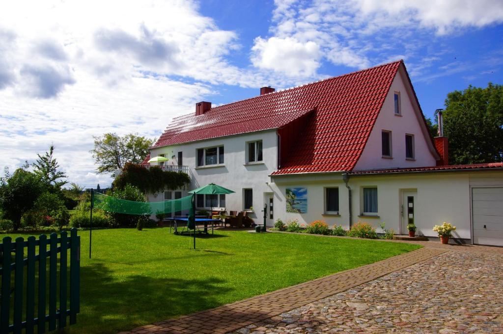 Casa blanca con techo rojo y patio en Urlaub auf der Insel Rügen, en Bergen auf Rügen
