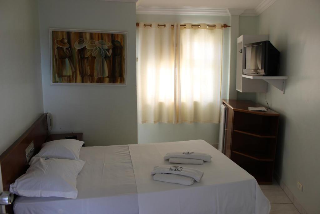 1 dormitorio con 1 cama con 2 toallas en Apart Service Araras - VPC, en Caldas Novas