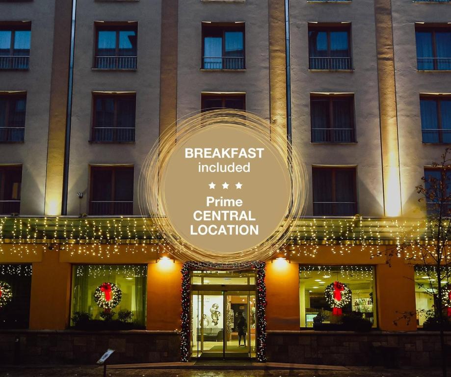 ein Schild an der Vorderseite eines Gebäudes mit Weihnachtsbeleuchtung in der Unterkunft City Hotel Ljubljana in Ljubljana