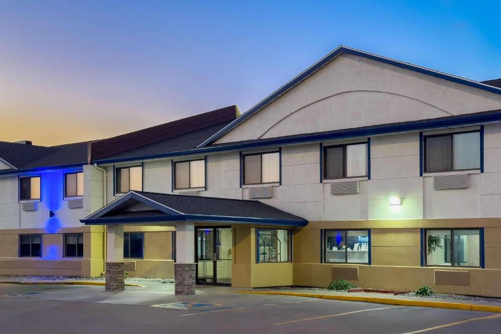 ein Hotel mit einem Gebäude mit einem Parkplatz in der Unterkunft Travelodge by Wyndham Fargo in Fargo