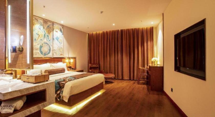 Cette grande chambre comprend un lit et une télévision. dans l'établissement James Joyce Coffetel· Yinchuan International Exhibition Center Wanda Square Qinshui Street, à Yinchuan