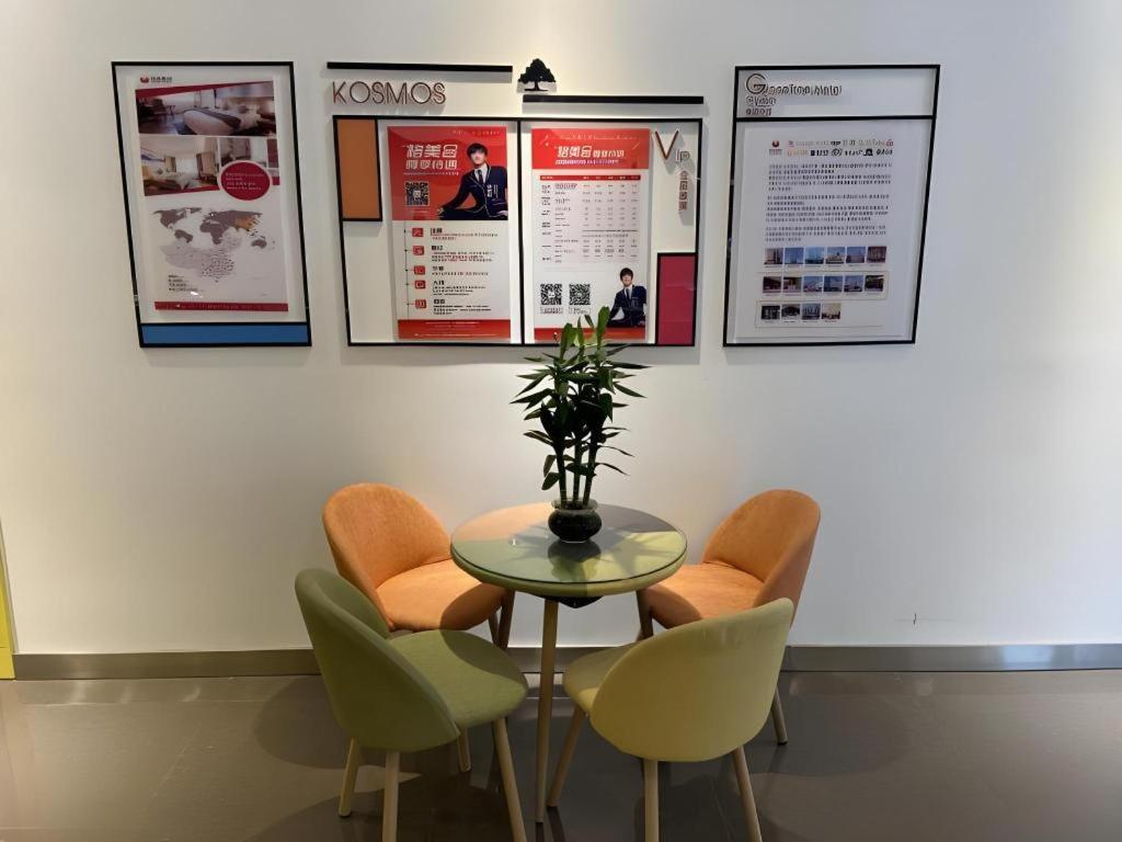 une table avec des chaises et des affiches sur un mur dans l'établissement Shell Hotel Yinchuan Xingqing District Yuhuangge Street, à Yinchuan