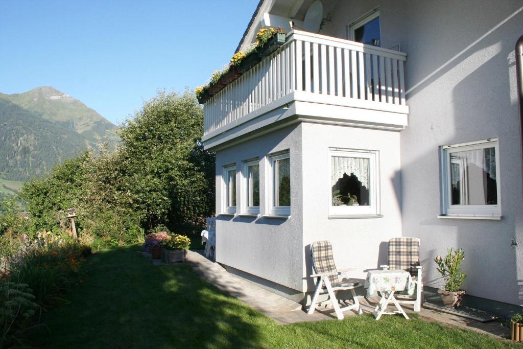 ein weißes Haus mit 2 Stühlen und einem Balkon in der Unterkunft Ferienwohnung Großvenediger in Virgen