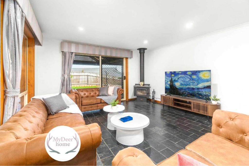 un salon avec un canapé et une télévision dans l'établissement Coastal Comfort 4BR Vacation Home in Hallett Cove, à Halletts Cove