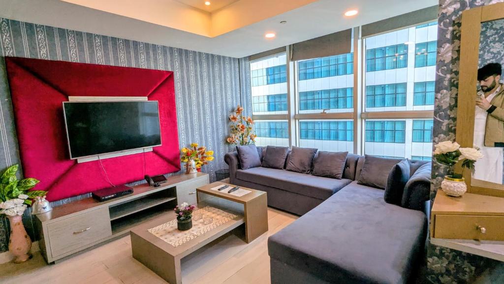 a living room with a couch and a flat screen tv at Centaurus mall two bed apartment in Islamabad