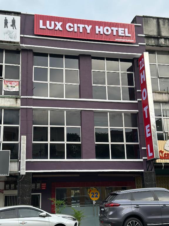 two cars parked in front of a luxury hotel at Lux City Hotel in Seremban