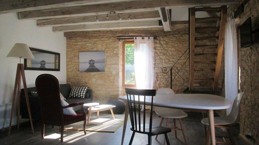 a living room with a table and chairs and a couch at La Petite Maison in Condat-sur-Vézère