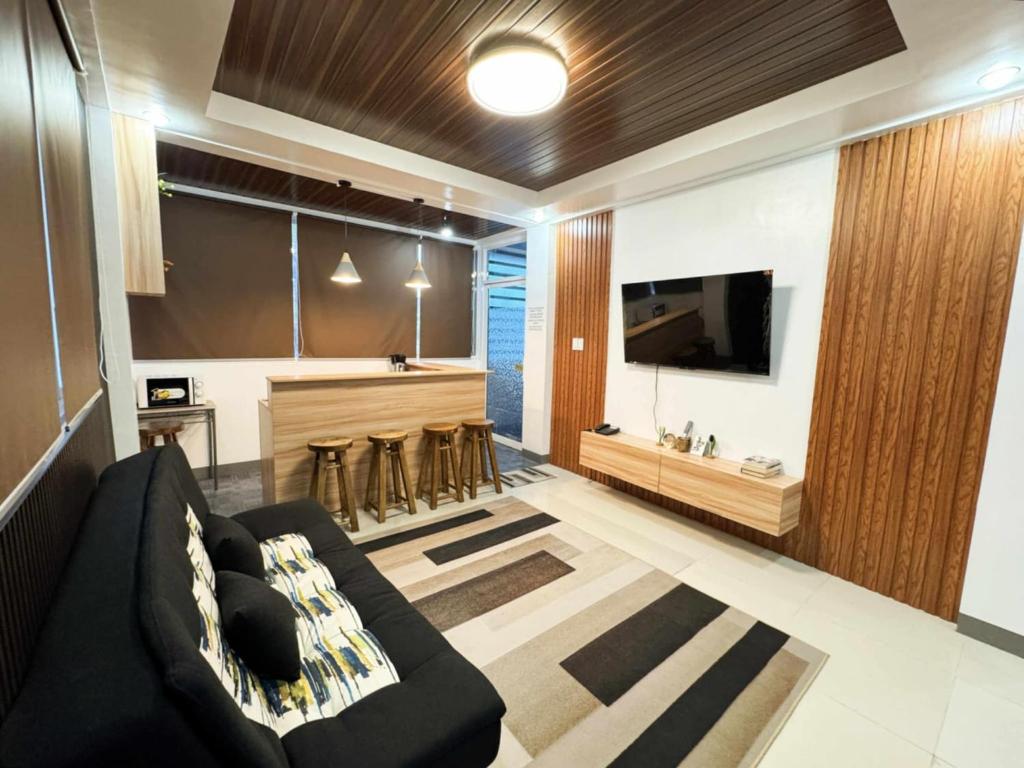 Una sala de estar con un sofá y un bar. en JL Valley Suites, en Ciudad de Cauayán