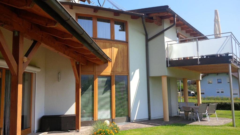 a house with glass doors and a balcony at Haus Astrid in Keutschach am See