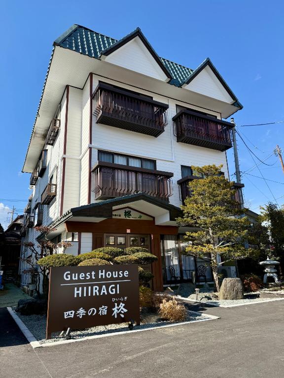 a guest house himachi with a sign in front of it at Guest House HIIRAGI in Yamanakako