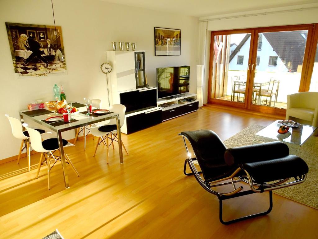ein Wohnzimmer mit einem Tisch, Stühlen und einem TV in der Unterkunft Seeperle 2 in Meersburg